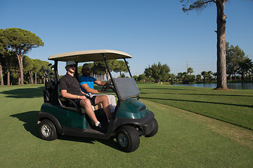 Image showing golf players driving cart at course