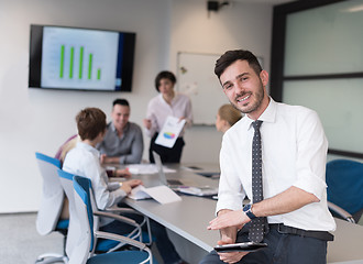 Image showing young business man with tablet at office meeting room