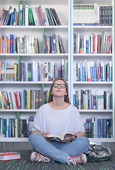 Image showing famale student reading book in library