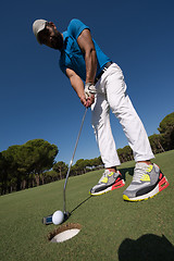 Image showing golf player hitting shot at sunny day, wide angle lens