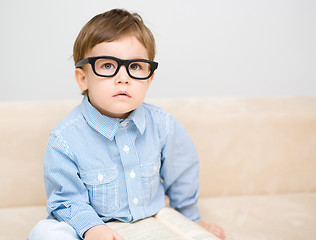 Image showing Little boy is reading book