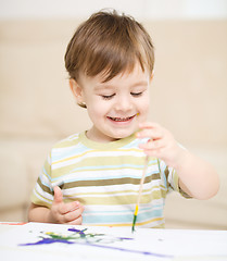 Image showing Little boy is playing with paints