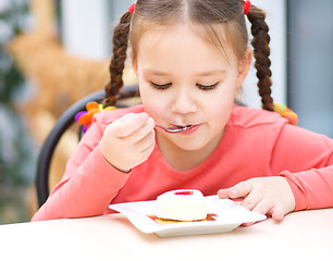 Image showing Little girl is eating cake in parlor