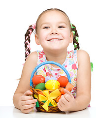 Image showing Little girl with basket full of colorful eggs