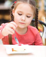 Image showing Little girl is eating cake in parlor