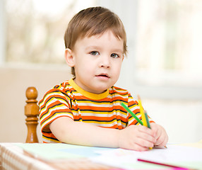 Image showing Little boy is drawing on white paper