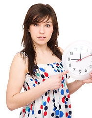 Image showing Young woman is holding big clock