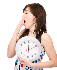 Image showing Young woman is holding big clock