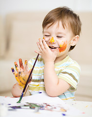 Image showing Little boy is playing with paints