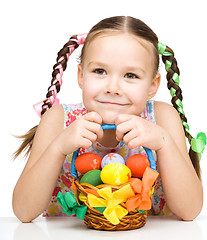 Image showing Little girl with basket full of colorful eggs