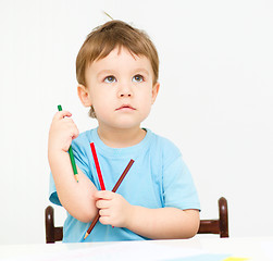 Image showing Little boy is drawing on white paper