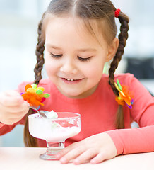 Image showing Little girl is eating ice-cream in parlor