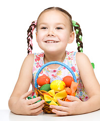 Image showing Little girl with basket full of colorful eggs