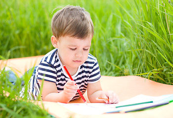 Image showing Little boy is playing with pencils