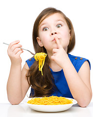 Image showing Little girl is eating spaghetti