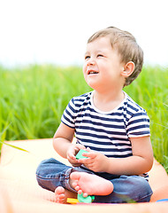 Image showing Little boy is playing with toys