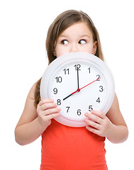 Image showing Little girl is holding big clock