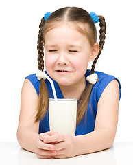 Image showing Sad little girl with a glass of milk