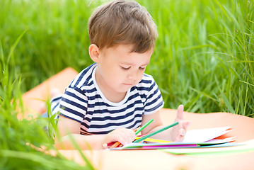 Image showing Little boy is playing with pencils