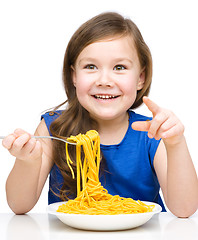 Image showing Little girl is eating spaghetti