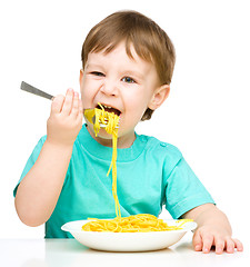 Image showing Little boy is eating spaghetti