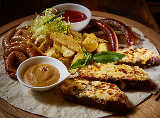 Image showing Assorted fried sausages, grilled potatoes, sauce Adjika, Mustard Sauce