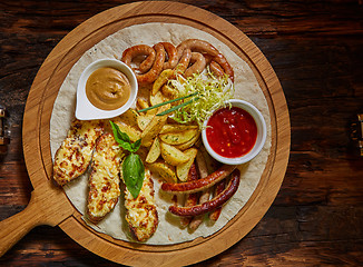 Image showing Assorted fried sausages, grilled potatoes, sauce Adjika, Mustard Sauce