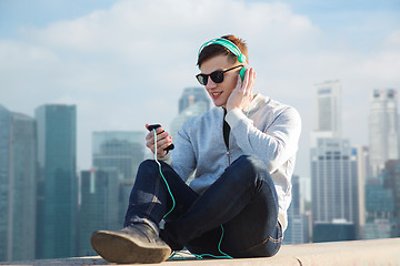 Image showing happy young man in headphones with smartphone