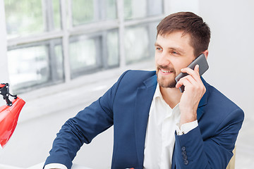 Image showing Portrait of businessman talking on phone in office