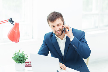 Image showing Portrait of businessman talking on phone in office