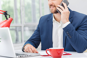 Image showing Portrait of businessman talking on phone in office