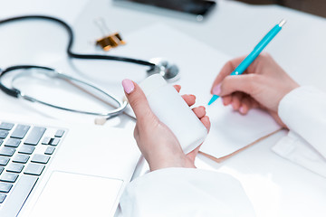 Image showing The hands of doctor woman writing at the medical office