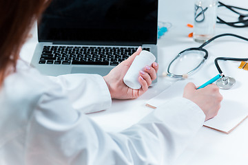 Image showing The hands of doctor woman writing at the medical office