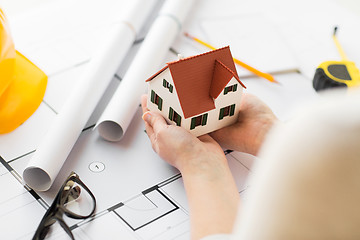 Image showing close up of hands with house model above blueprint