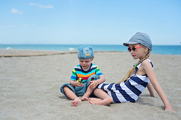 Image showing Two small kids sitting on the beach