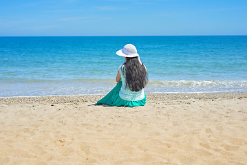 Image showing Brunette with long hair turned away and sitting