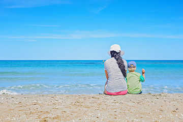 Image showing Brunette with long hair and kid turned away