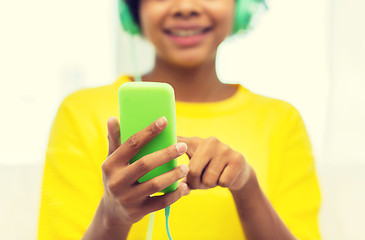 Image showing happy african woman with smartphone and headphones