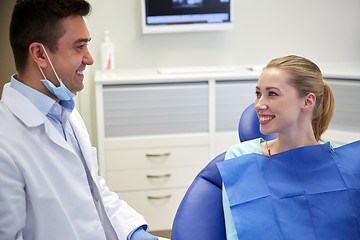 Image showing happy male dentist with woman patient at clinic