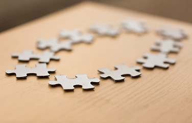 Image showing close up of puzzle pieces on wooden surface