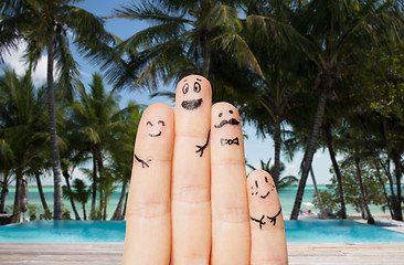 Image showing close up of fingers with smiley faces on beach