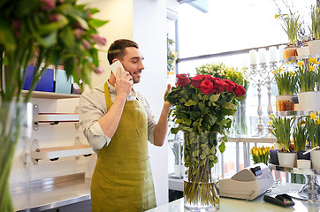 Image showing man with smartphone and red roses at flower shop