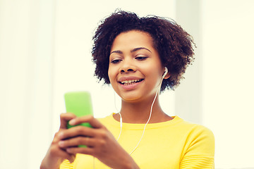 Image showing happy african woman with smartphone and earphones