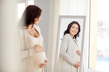 Image showing happy pregnant woman looking to mirror at home