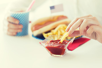 Image showing close up of woman hands eating on american food