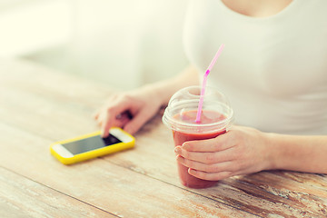 Image showing close up of woman with smartphone and smoothie