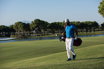Image showing golf player walking and carrying bag