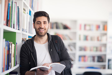 Image showing portrait of student while reading book  in school library