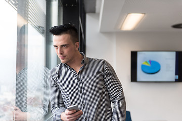 Image showing young business man using smart phone at office