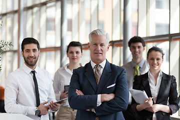 Image showing portrait of senior businessman as leader  with group of people i